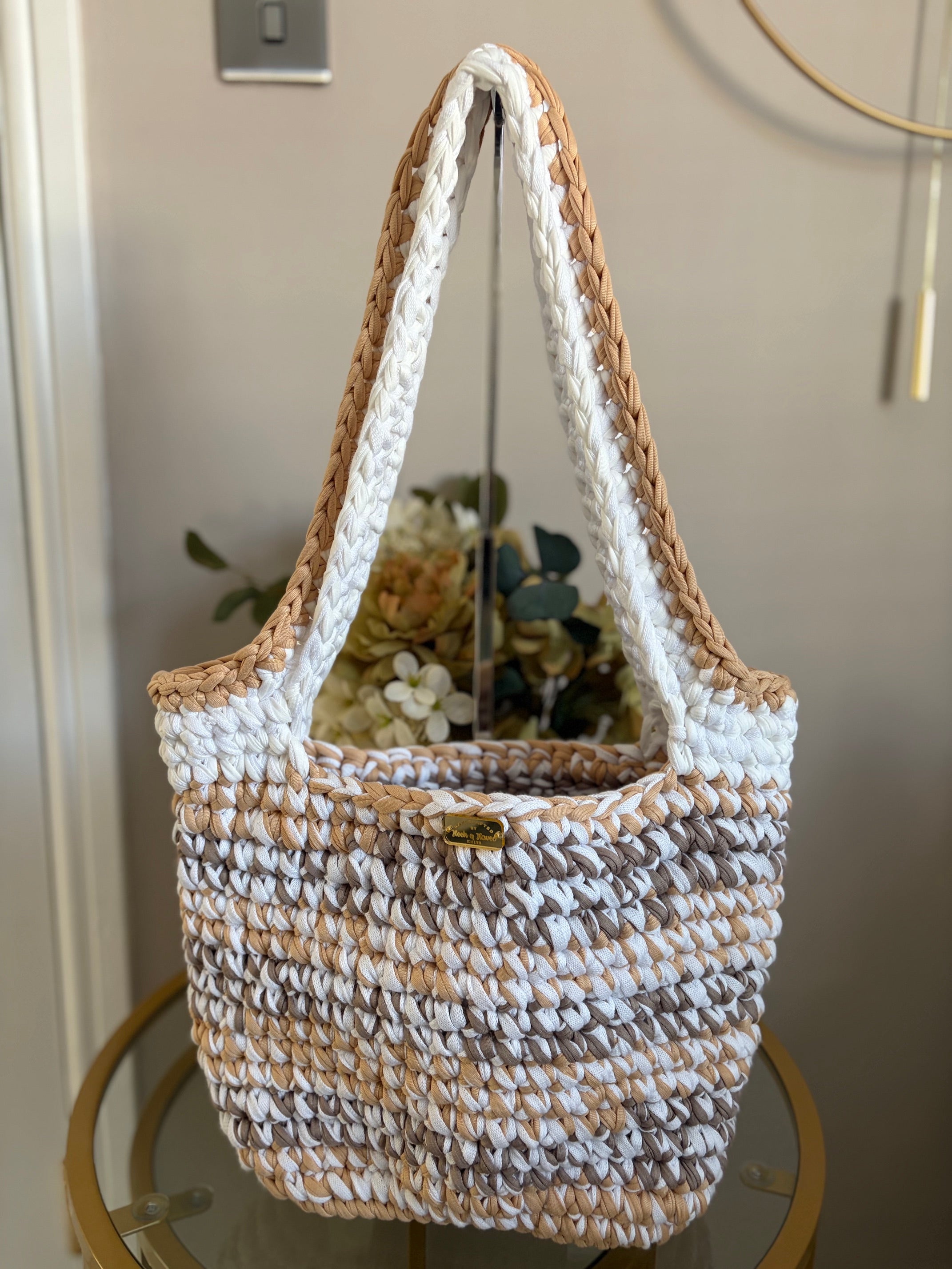 A woven crochet tote bag with thick braided shoulder straps