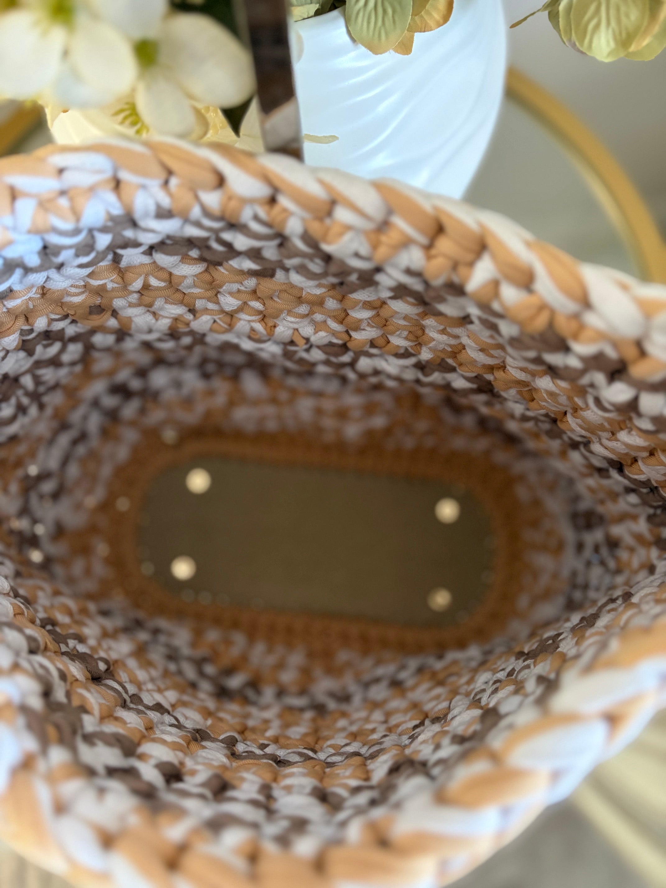 Top-down view of a crochet bag with a braided beige, white, and brown pattern