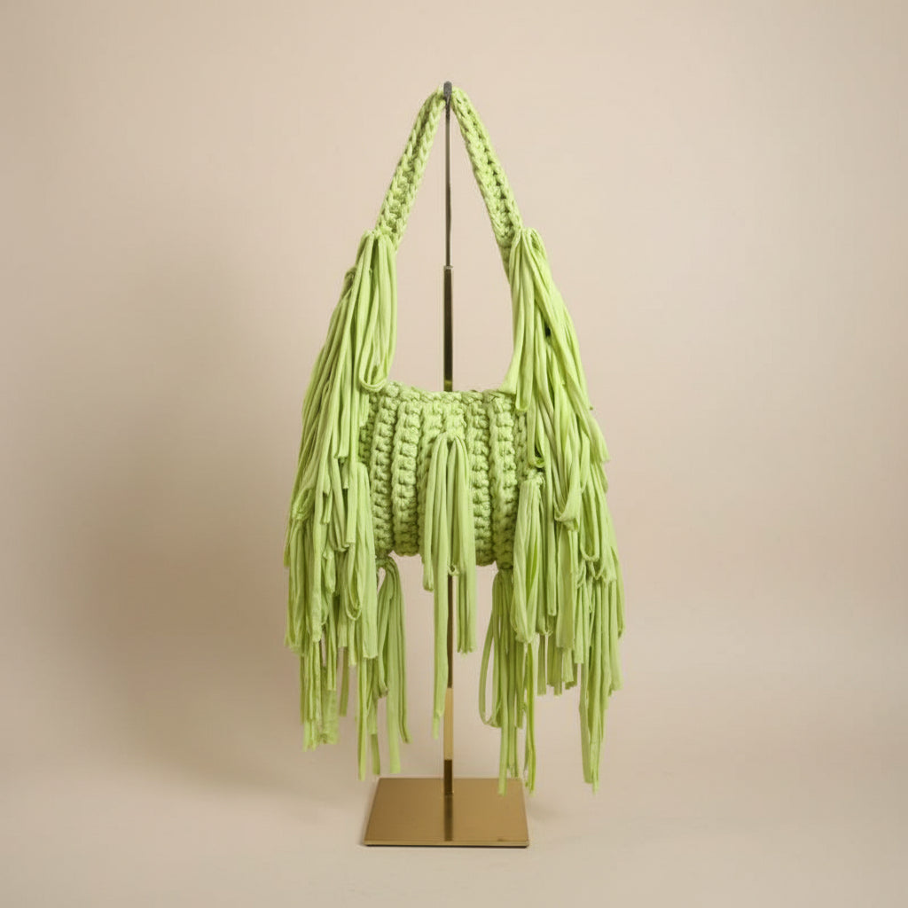 A light green chunky crochet fringed handbag