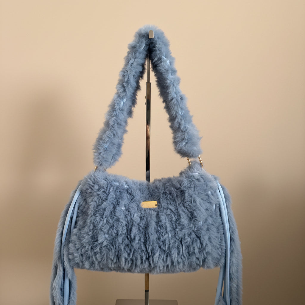 A light blue fuzzy faux-fur shoulder bag with a matching strap
