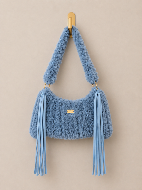 Blue textured handbag with tassels on a beige background