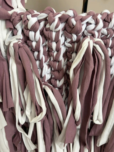 Close-up of braided fabric with purple and white colours.